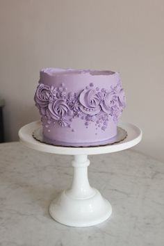 a purple cake sitting on top of a white plate