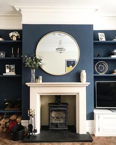 a living room with a fire place and a round mirror on the wall above it