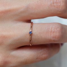 a close up of a person's hand with a gold ring on their finger