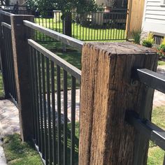 a wooden fence with metal posts in front of a house