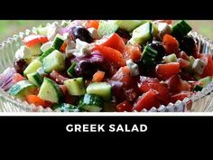 greek salad with cucumbers, olives, tomatoes and feta cheese in a glass bowl