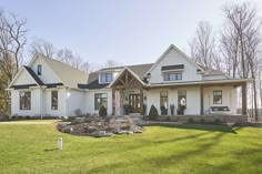 a large white house sitting on top of a lush green field