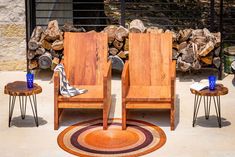 two wooden chairs sitting next to each other on top of a floor covered in rugs