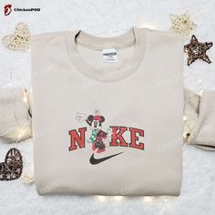 The Minnie Mouse Retro x Nike Christmas Embroidered Sweatshirt is the perfect gift for Disney fans this holiday season. Featuring a classic Minnie Mouse design with a festive touch, this sweatshirt is made with high-quality materials for ultimate comfort. The embroidered details add a charming and unique touch. Whether you’re lounging at home or out and about, this sweatshirt will keep you cozy and stylish. Get ready to spread holiday cheer with this must-have piece. The Minnie Mouse Retro Luxury Logo Sweatshirt For Winter, Luxury Winter Sweatshirt With Embroidered Logo, Luxury Hoodie Sweatshirt With Embroidered Logo, Luxury Embroidered Logo Hoodie Sweatshirt, Disney Christmas Minnie Red Head Sweatshirt, Nike Cartoon, Disney Character Shirts, Nike Inspired, Timmy Turner