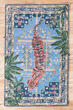 a rug with a tiger in the middle on top of a wooden floor and leaves around it