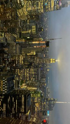 an aerial view of the city skyline at night with skyscrapers lit up in yellow and blue