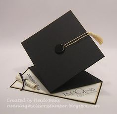 a black graduation cap and tassel on top of an envelope with a note attached