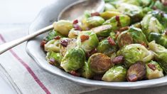 brussel sprouts with bacon in a silver bowl on a red and white towel