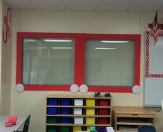 an empty classroom with red and white windows