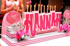 a table topped with lots of candy and lollipops next to a giant thank you sign