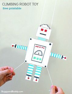 two hands holding up a paper robot that is hanging from strings with text overlay reading, gliding robot free printable