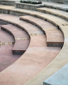 an empty stage with steps and benches in the center, surrounded by concrete blocks on either side