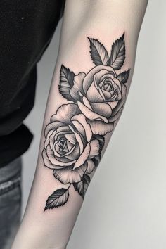 a black and white rose tattoo on the arm