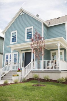 a blue house with white trim and stairs