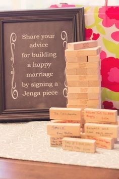 some wooden blocks stacked on top of each other in front of a sign that says share your advice for building a happy marriage by signing a