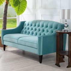 a blue couch sitting next to a wooden table