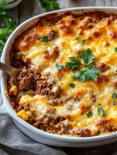 a casserole dish with meat, cheese and parsley on the top is ready to be eaten