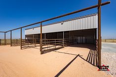 an empty horse barn in the desert on a sunny day with no people or animals