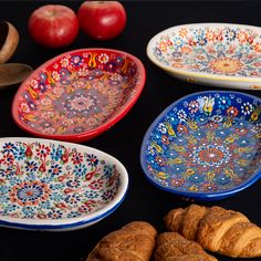 several colorful plates and croissants on a table