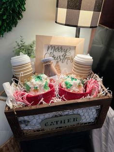 a wooden box filled with christmas treats on top of a table next to a lamp