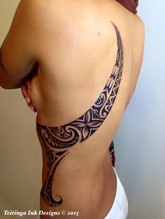 the back of a woman's stomach with an intricate tattoo design on her ribs