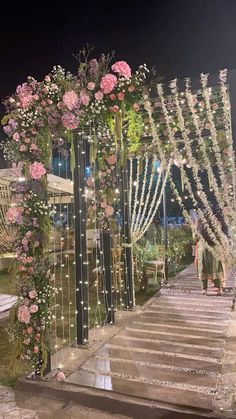 an outdoor wedding setup with flowers and lights