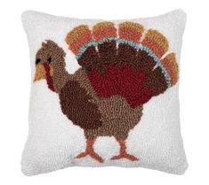 a white pillow with a turkey embroidered on it