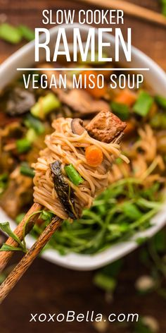 a bowl filled with noodles and vegetables on top of a wooden table