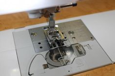 the sewing machine is on top of the white piece of paper that has been sewn