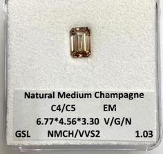 an emerald colored diamond is on display in a glass case, with the price label below it