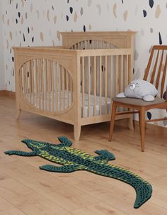 a baby crib with an alligator rug on the floor