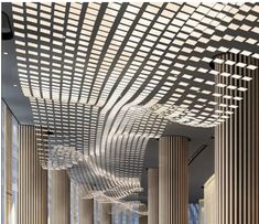 the interior of a large building with columns and lights hanging from it's ceiling