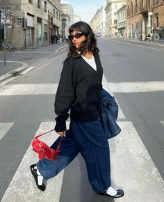 Spring layered outfit with a white tee, black cardigan, and dark blue jeans , wearing black ballerina flats and white socks with a pop of red purse walking photo spring aesthetic outfit style inspo 2024 it girl clean girl fashion Winter Flats Shoes Outfit, Winter Outfit Jeans Casual, Grandma Shoes Outfit, Black Fitted Tee Outfit, Flats And Socks Outfit, Outfits With Big Bags, Ballerina Flats With Socks, Ballerina Flat Outfits, Outfits With Rothy Clogs