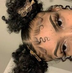 a close up of a person with tattoos on her face and curly hair in a bun