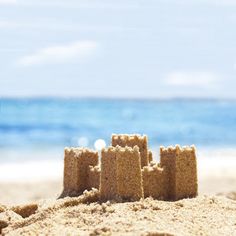 sand castle on the beach with blue water in the background