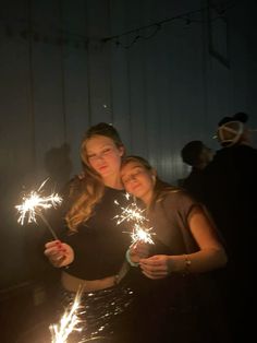 two girls are holding sparklers in their hands