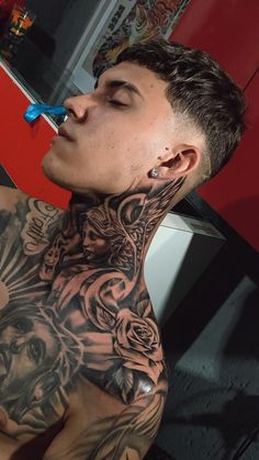 a man with tattoos on his neck and chest