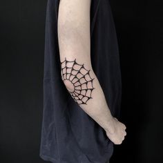 a person with a spider web tattoo on their left arm and the other arm is black