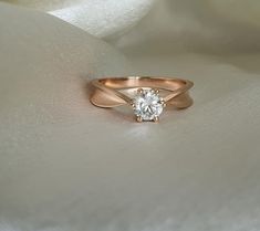 a white diamond ring sitting on top of a white cloth