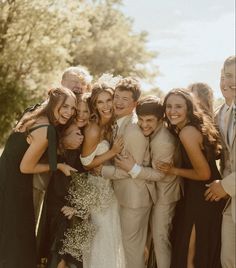 a group of people standing next to each other posing for a photo in front of trees