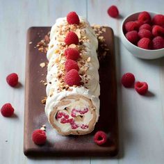 a dessert roll with raspberries and nuts on top