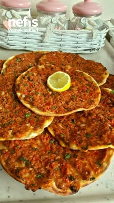 some food that is sitting on top of a tray with lemon wedges next to it