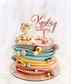 a birthday cake with a cat sitting on top of it's tiered layers