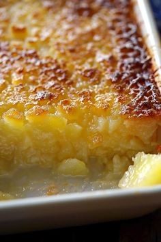 a close up of a casserole dish on a plate with lemon wedges