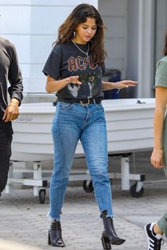 a woman in black shirt and jeans walking