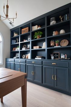 an empty room with blue bookcases and wooden table