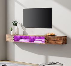 a tv mounted on a wall above a shelf