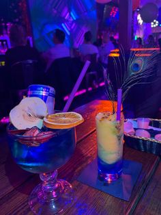 two cocktails sitting on top of a wooden table