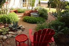 a red chair sitting in the middle of a garden