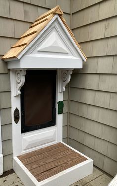 a white dog house with a brown roof